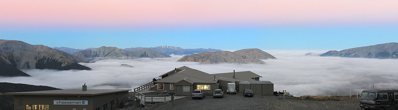 The night lodge with lights glowing, above a layer of cloud at sunset